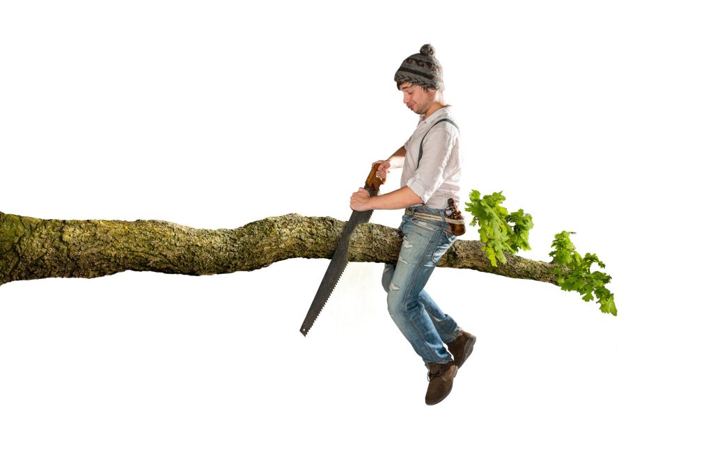 Man making the mistake of sawing off the branch he's sitting on