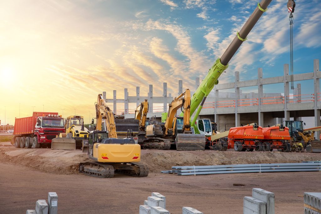 Many different multiclored colorful heavy industrial machinery equipment at construction site parking area