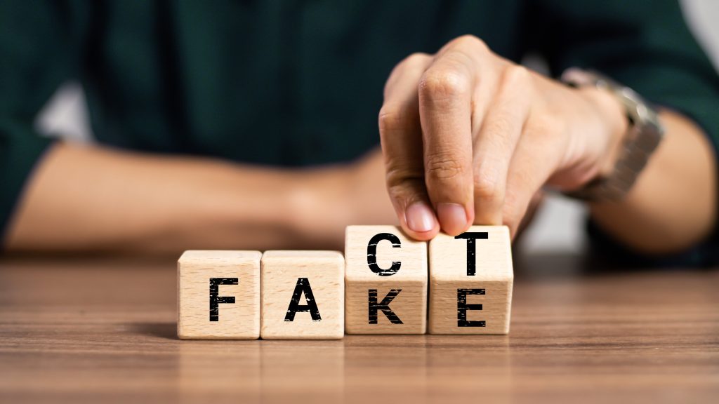 Fact or Fake concept, Hand flip wood cube change the word, April fools day